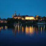 Wawel Castle at night reflected on the Vistula River in Kraków