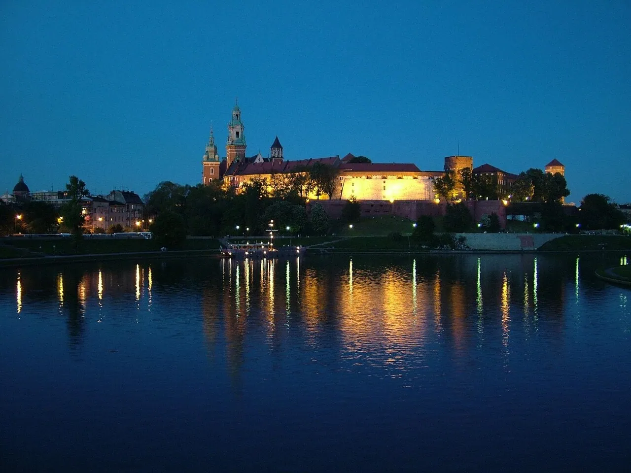 Wawel Castle at night reflected on the Vistula River in Kraków