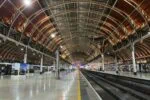 London Paddington train station platform with trains and Victorian roof structure
