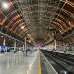 London Paddington train station platform with trains and Victorian roof structure