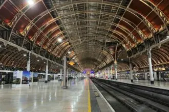 London Paddington train station platform with trains and Victorian roof structure