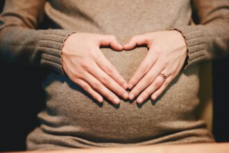 Pregnant woman holding her bump preparing for safe air travel during pregnancy