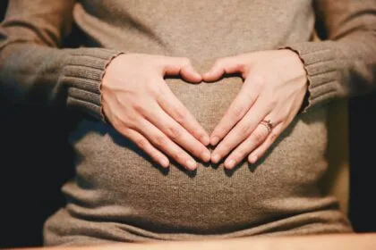 Pregnant woman holding her bump preparing for safe air travel during pregnancy