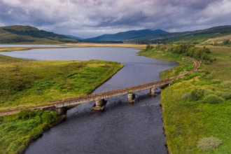 Scenic railway line crossing river in the Scottish Highlands ScotRail route