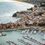 Sicily coastal town with harbour, boats and historic buildings overlooking the sea