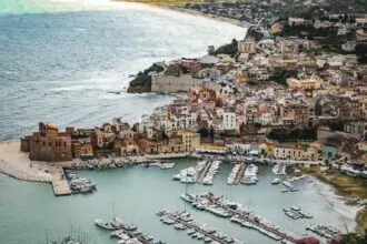 Sicily coastal town with harbour, boats and historic buildings overlooking the sea