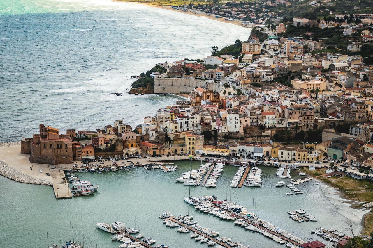 Sicily coastal town with harbour, boats and historic buildings overlooking the sea