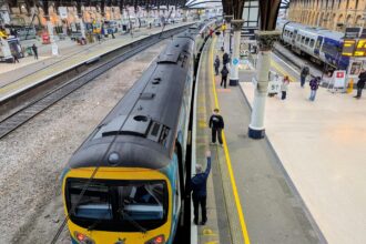 TransPennine Express train at York railway station platform with passengers
