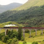 Steam train crossing Glenfinnan Viaduct on the West Highland Line in Scotland