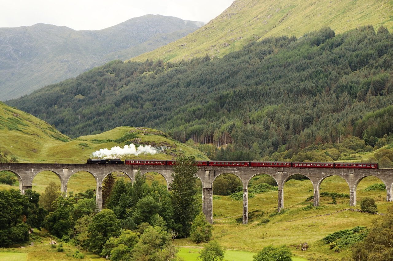 Steam train crossing Glenfinnan Viaduct on the West Highland Line in Scotland