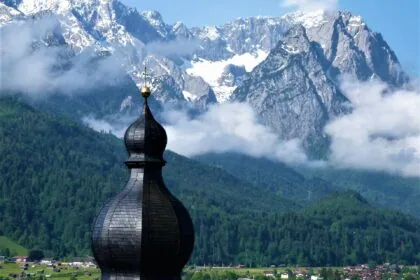 Zugspitze mountain in Germany with alpine village and church in foreground
