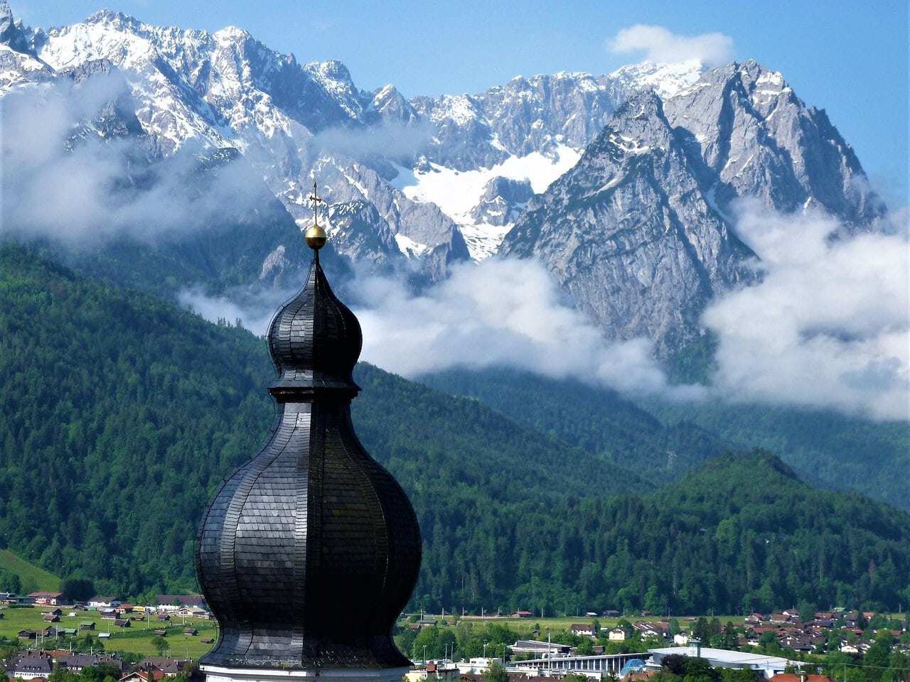 Zugspitze mountain in Germany with alpine village and church in foreground