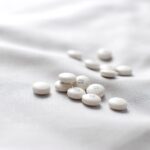 White antihistamine tablets on soft fabric background
