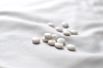 White antihistamine tablets on soft fabric background