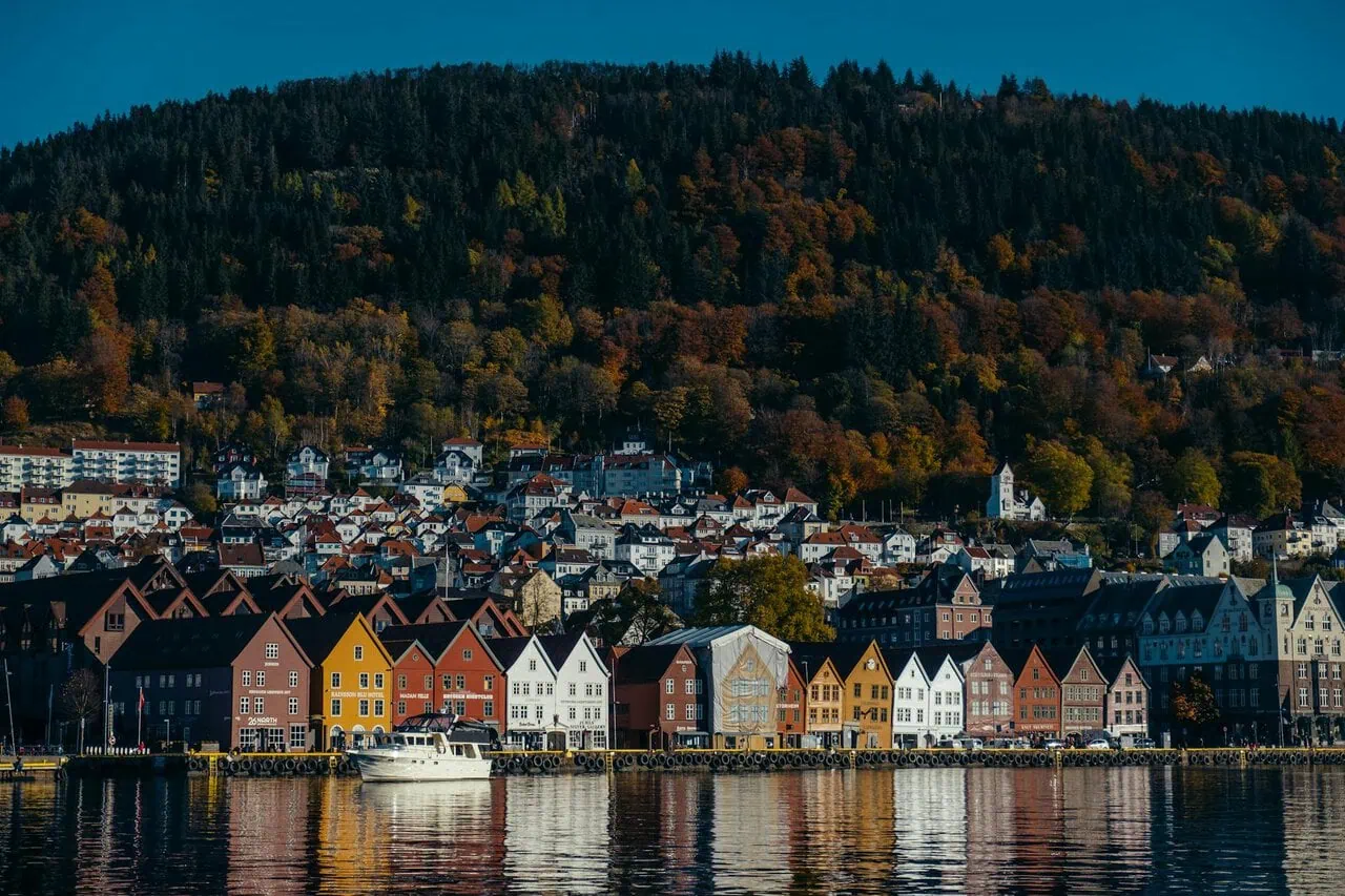 Colourful Bryggen waterfront reflected in Bergen harbour Norway