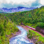 Scenic train travelling through mountains and rivers on the Bergen Line in Norway