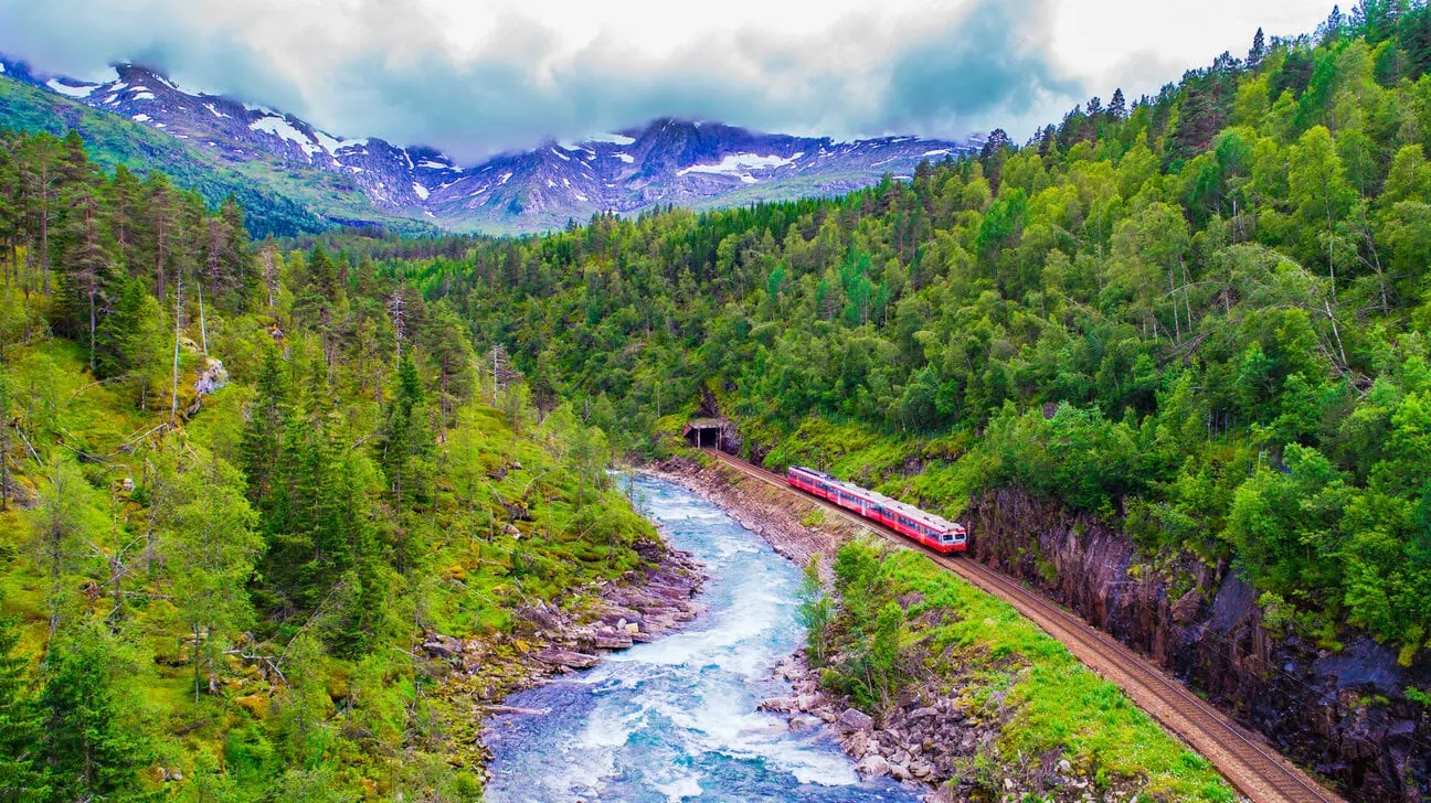 Scenic train travelling through mountains and rivers on the Bergen Line in Norway