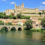 Historic riverside view of Béziers in southern France, one of the best day trips from Carcassonne.
