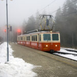 Historic Tatra cog railway train at a snowy mountain station in the High Tatras