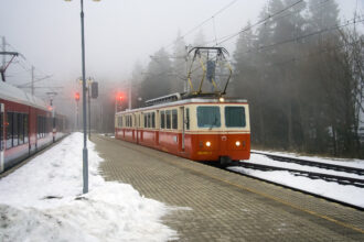 Historic Tatra cog railway train at a snowy mountain station in the High Tatras