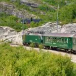 Flåm Railway train travelling through mountain scenery in Norway