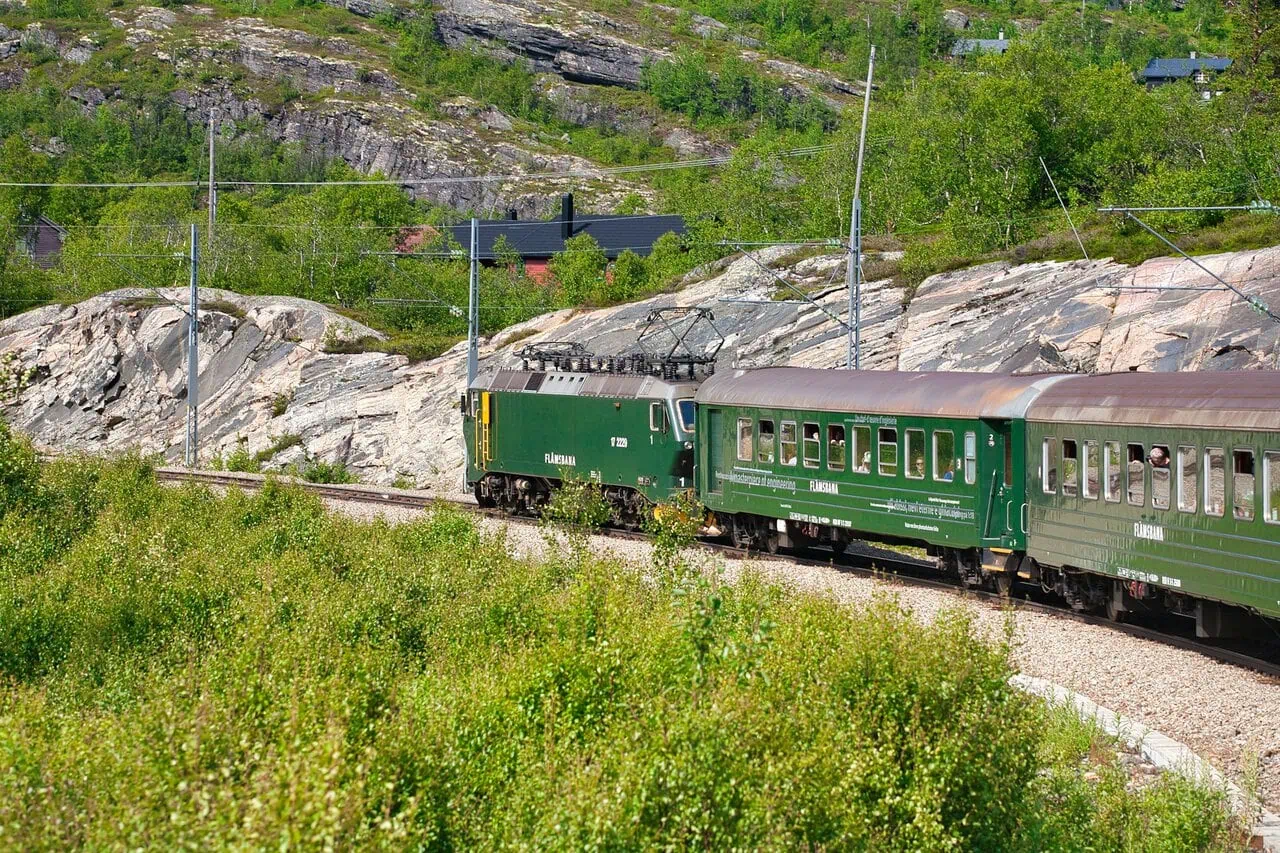FlĂĄm Railway train travelling through mountain scenery in Norway
