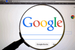 Magnifying glass over Google search page representing Google Flights extreme day trip planning and flight search tools