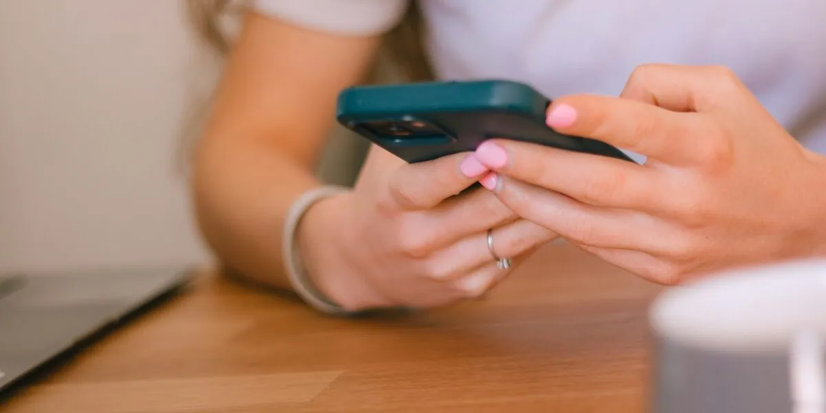 Person using a smartphone for travel eSIM connectivity and mobile data management