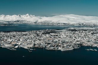 Tromsø skyline covered in snow beside Arctic mountains and fjords in northern Norway
