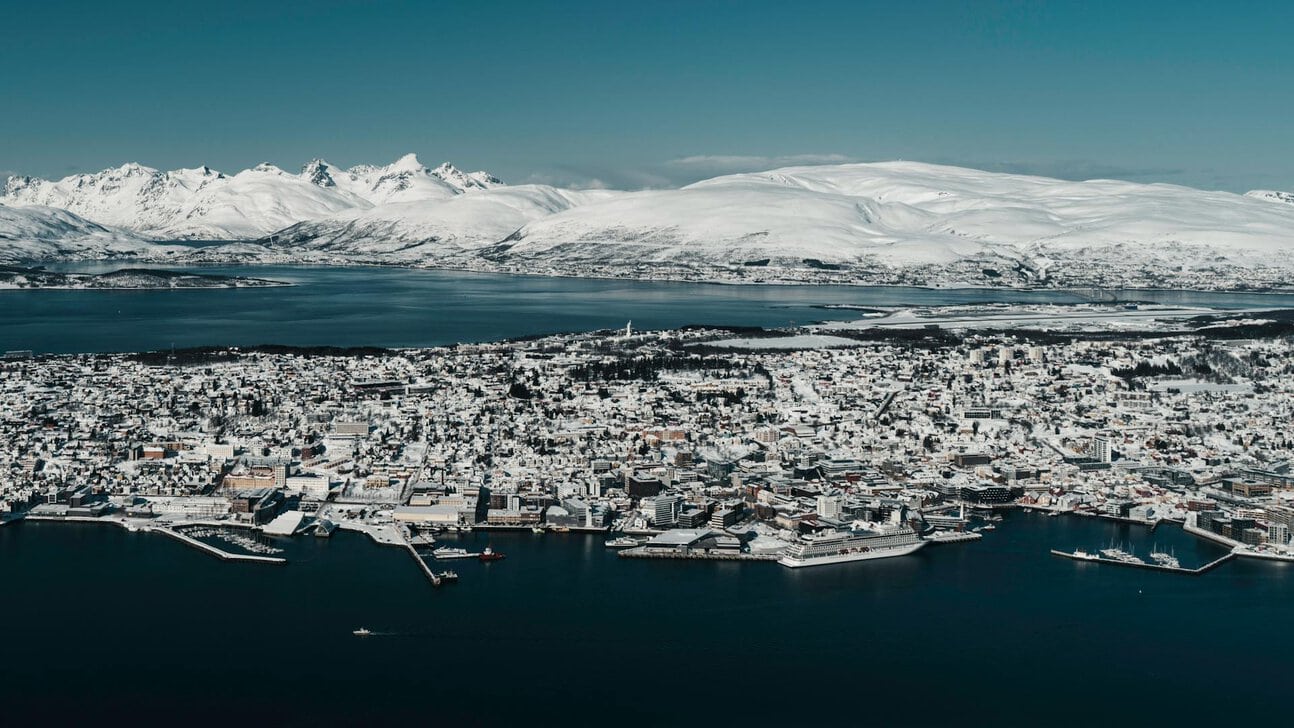 Tromsø skyline covered in snow beside Arctic mountains and fjords in northern Norway