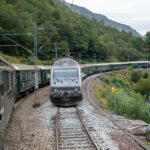 Norwegian overnight train passing through mountain scenery on a scenic rail route in Norway