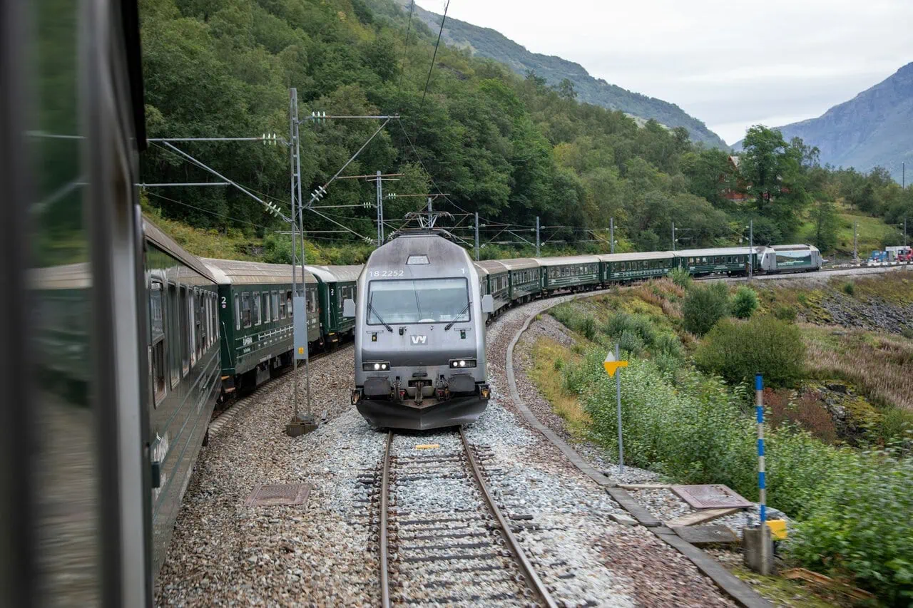 Norwegian overnight train passing through mountain scenery on a scenic rail route in Norway
