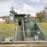 Exterior entrance to a preserved Cold War nuclear bunker in Britain with underground access stairs and security fencing