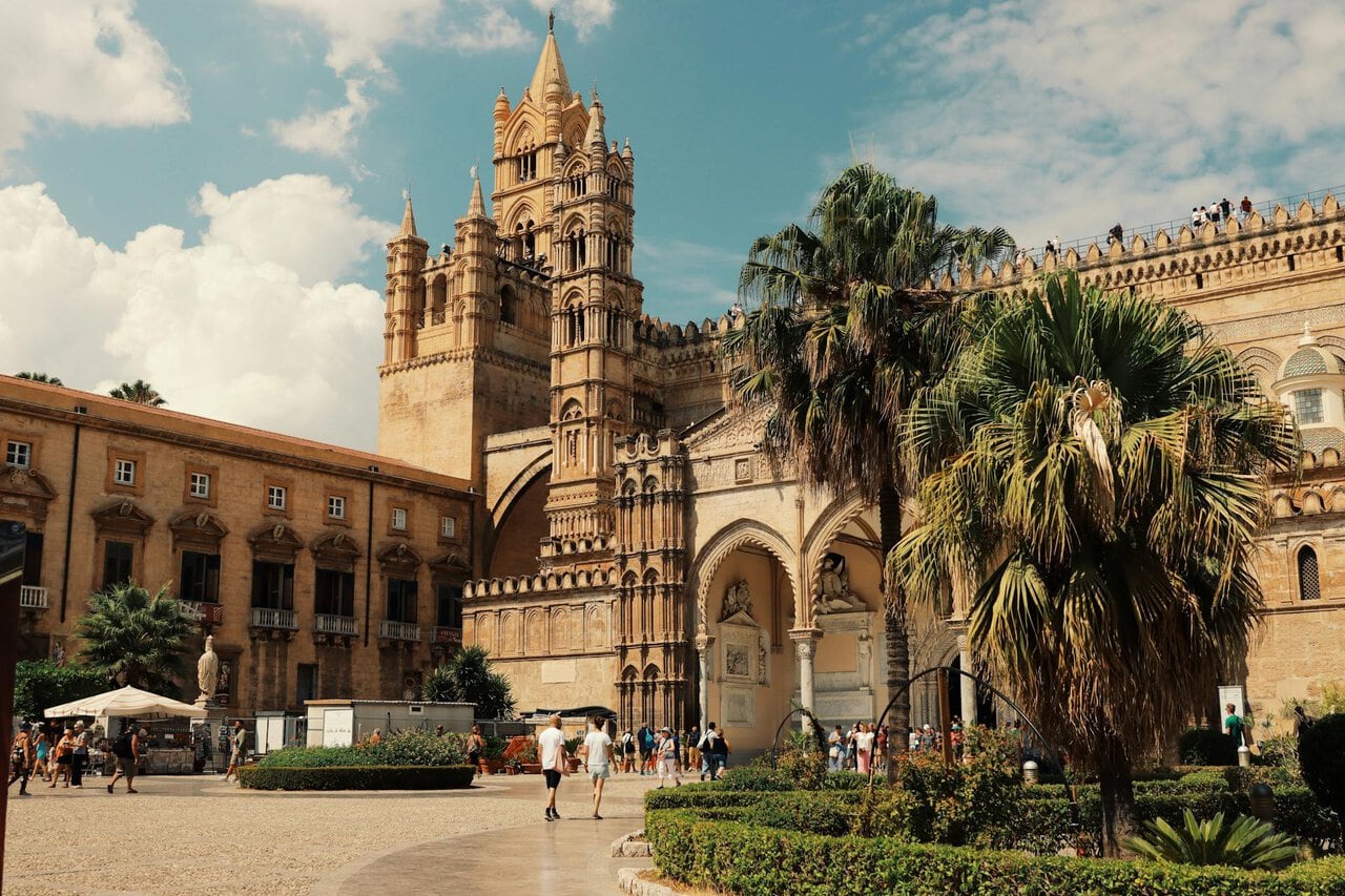 Historic Palermo Cathedral in central Palermo, Sicily, surrounded by palm trees and tourists near the city reached from Palermo Airport