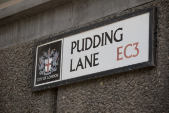 Pudding Lane street sign in the City of London marking the location where the Great Fire of London began in 1666.
