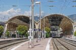 Platforms inside Nice-Ville railway station on the French Riviera with overhead power lines and historic station roof structure