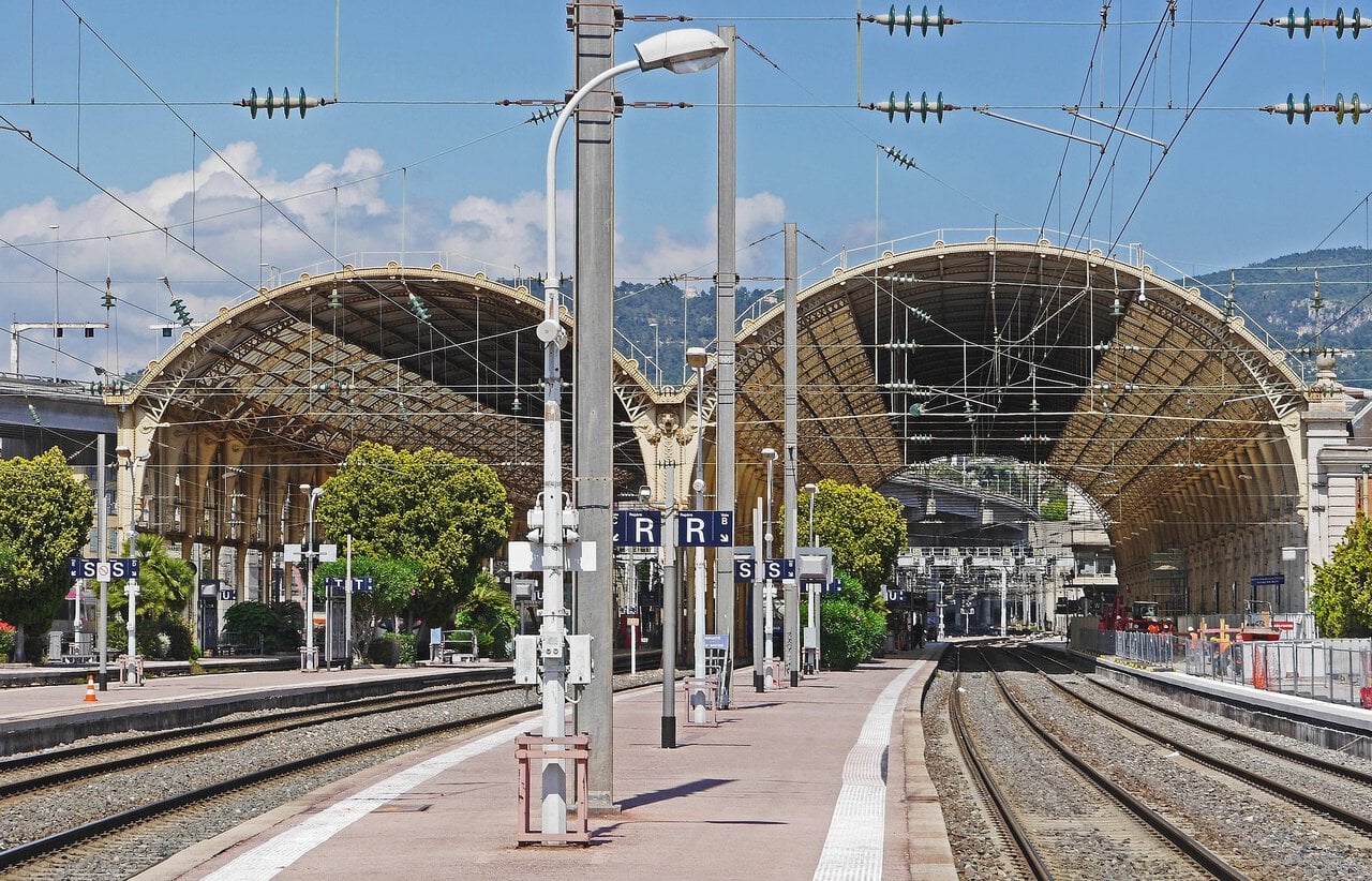 Platforms inside Nice-Ville railway station on the French Riviera with overhead power lines and historic station roof structure