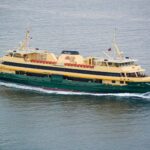 Large passenger ferry travelling across calm coastal waters during daylight