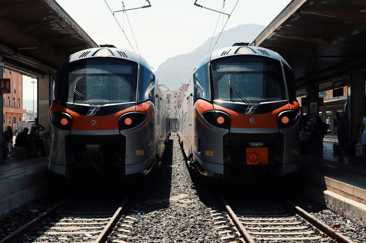 Modern Trenitalia regional trains standing at a railway station in Sicily, used for rail travel between cities such as Palermo, Catania, and Messina