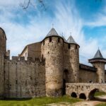 The fortified towers and defensive walls of UNESCO Carcassonne in southern France under a bright blue sky.