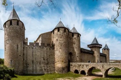 The fortified towers and defensive walls of UNESCO Carcassonne in southern France under a bright blue sky.