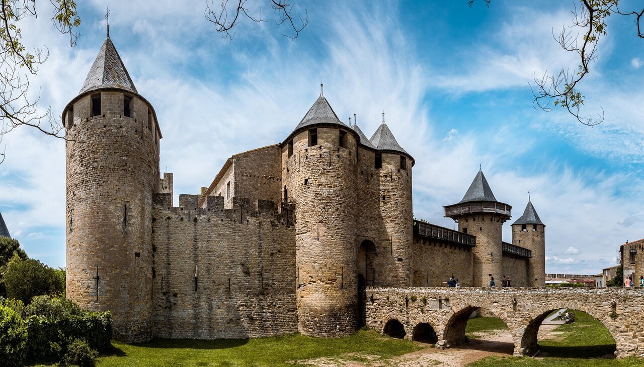 The fortified towers and defensive walls of UNESCO Carcassonne in southern France under a bright blue sky.
