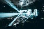 Large live concert arena in Vienna with stage lighting and crowds during Eurovision style music event