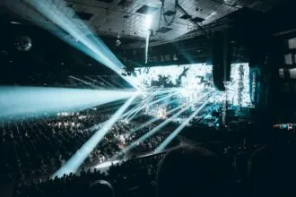 Large live concert arena in Vienna with stage lighting and crowds during Eurovision style music event