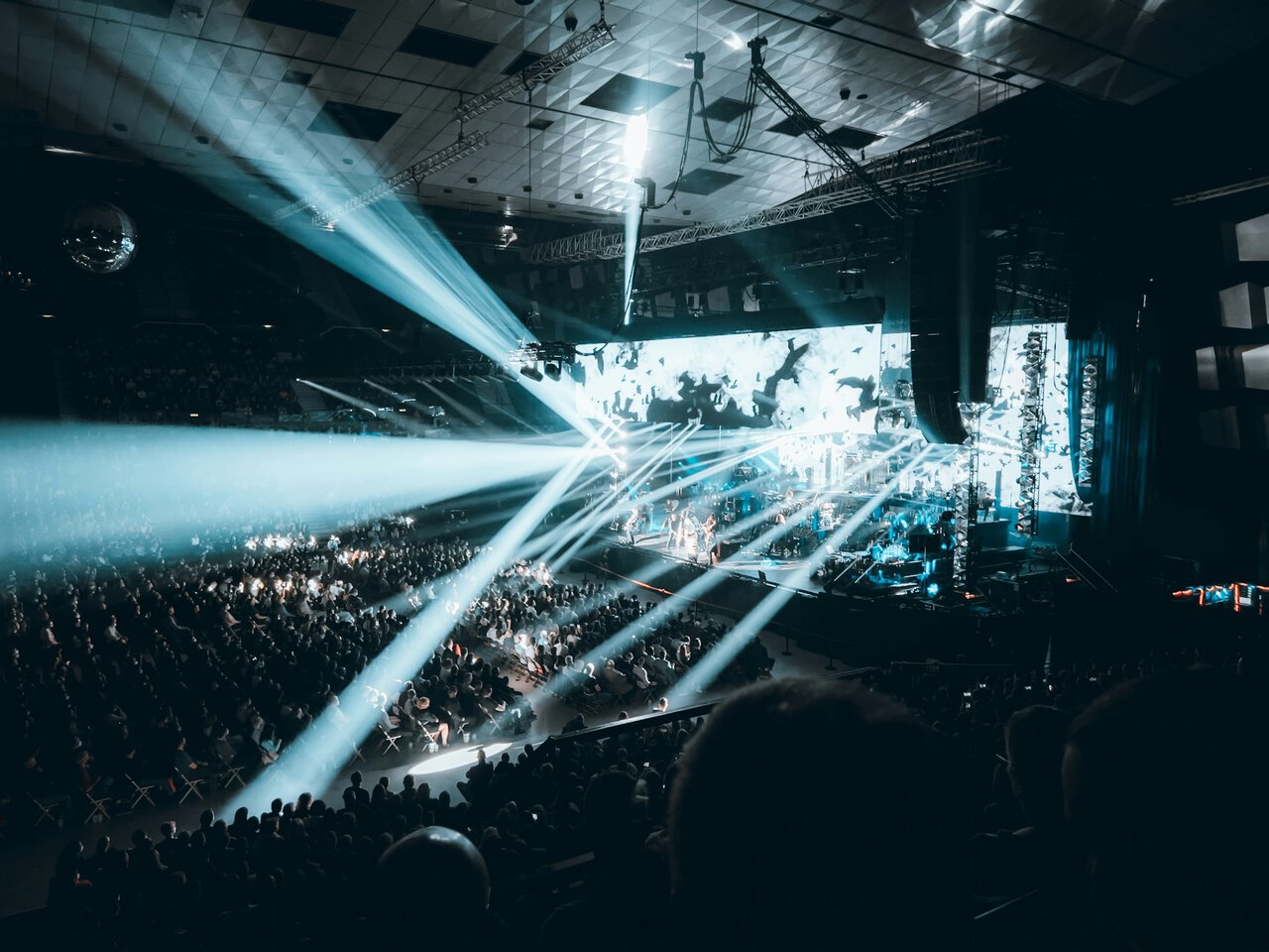 Large live concert arena in Vienna with stage lighting and crowds during Eurovision style music event