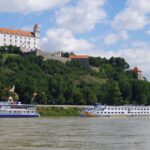 Bratislava Castle overlooking the Danube River with river cruise boats in Bratislava, Slovakia
