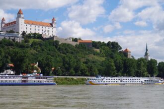 Bratislava Castle overlooking the Danube River with river cruise boats in Bratislava, Slovakia
