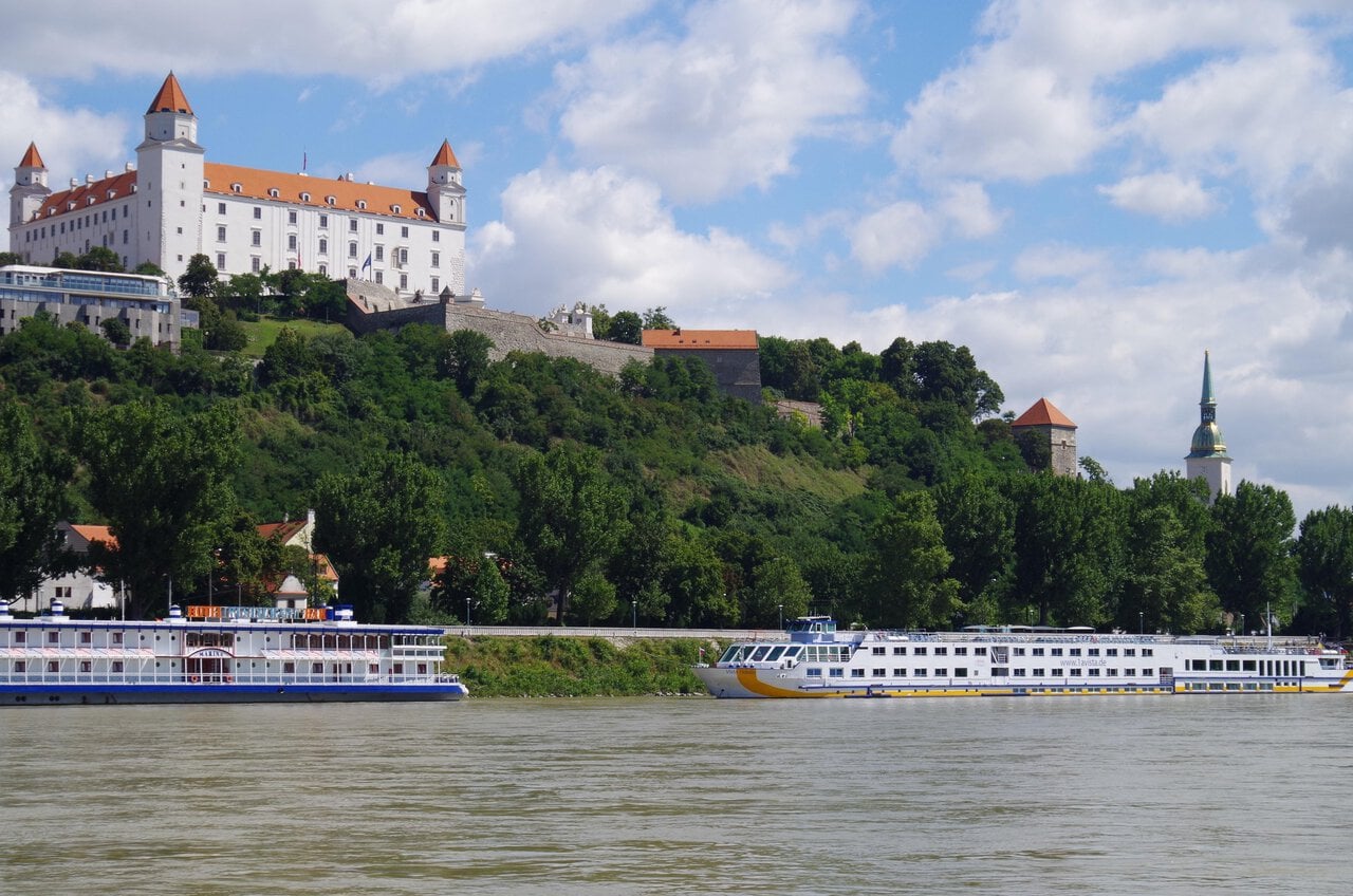 Bratislava Castle overlooking the Danube River with river cruise boats in Bratislava, Slovakia
