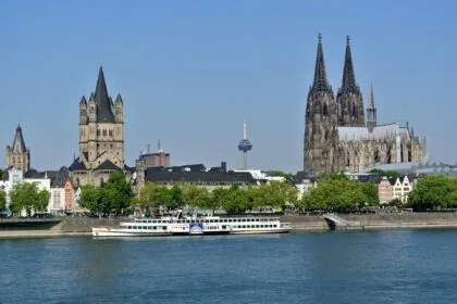 Cologne skyline viewed from the Rhine River with Cologne Cathedral and Great St. Martin Church dominating the historic cityscape.