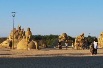 Visitors exploring sand sculptures at the Burgas Sand Festival.